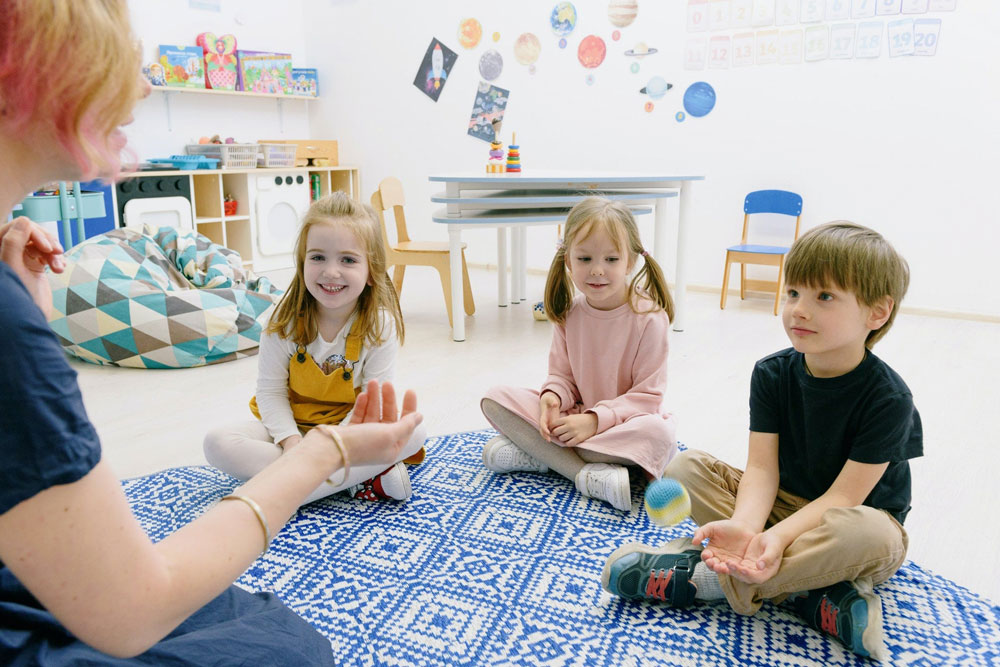 maestra-e-bambini-giocano-scuola-infanzia-min